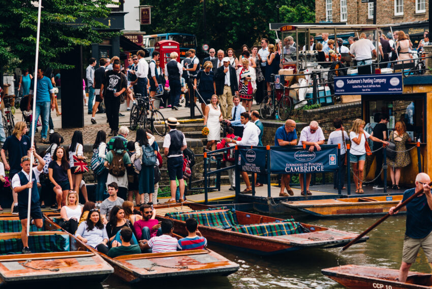 Guests boarding punts along the River Cam on a busy summer day