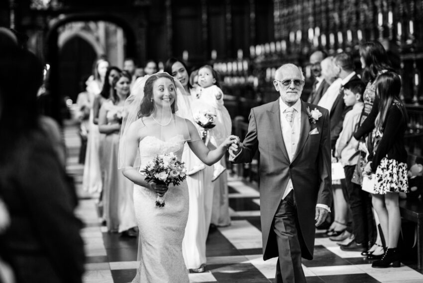 Bride and father walking down the aisle at King’s College chapel, Cambridge