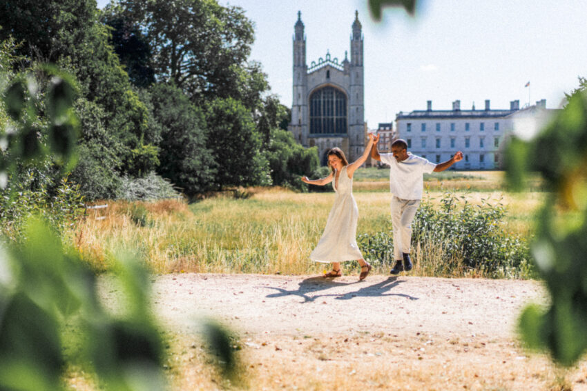 Couple dancing and laughing at The Backs with King’s College Chapel behind them, Cambridge wedding photography