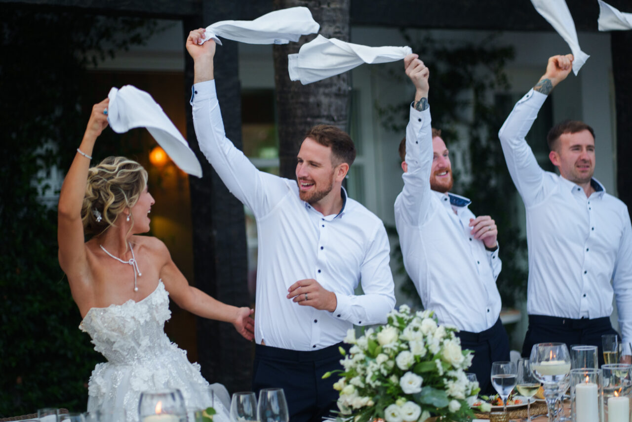 Bride and guests waving napkins during a fun wedding reception moment