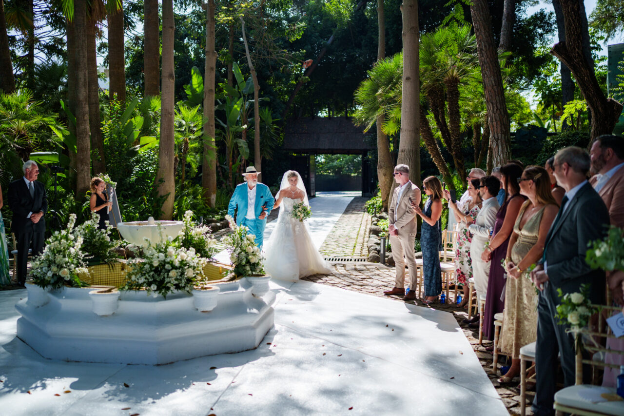 Marbella wedding photo - a bride and her father walk down the aisle.