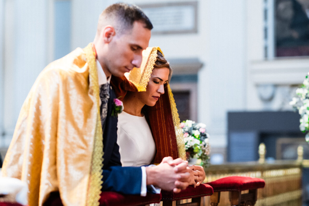 Couple kneeling during a traditional church ceremony, wedding in Spain