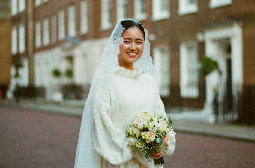 35mm film portrait of a bride in London - she is holding flowers and is standing in a London street.