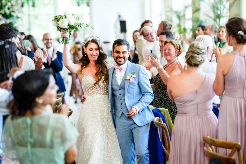 Bride and groom smile as the make their entrance into their wedding reception