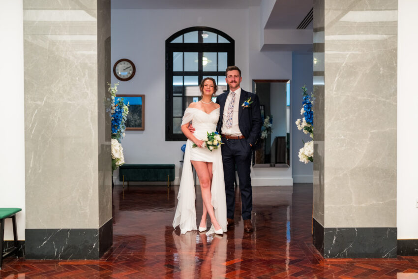 Bride and groom standing together in the entrance hall at Camden Town Hall before their wedding ceremony.