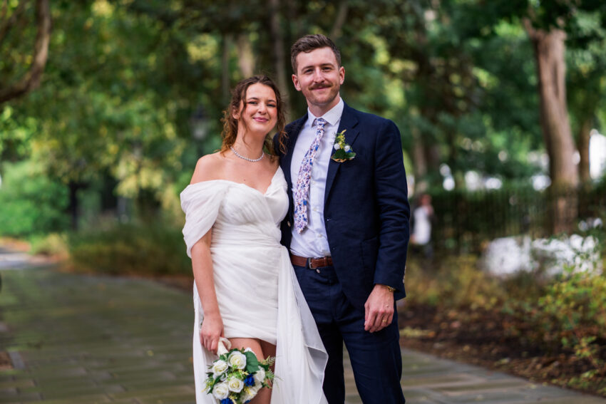 Bride and groom standing together for relaxed portraits outdoors following the ceremony.