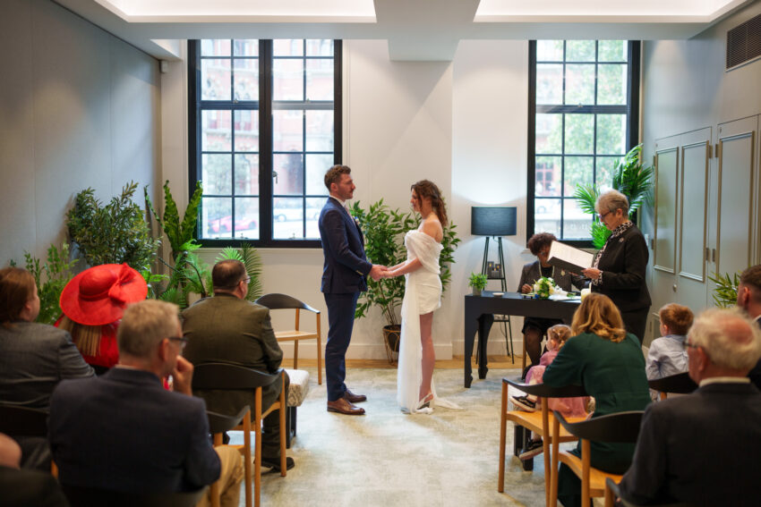 Bride and groom standing together during their wedding ceremony at Camden Town Hall.