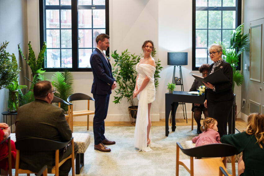 Bride and groom listening to the registrar during their wedding ceremony at Camden Town Hall.