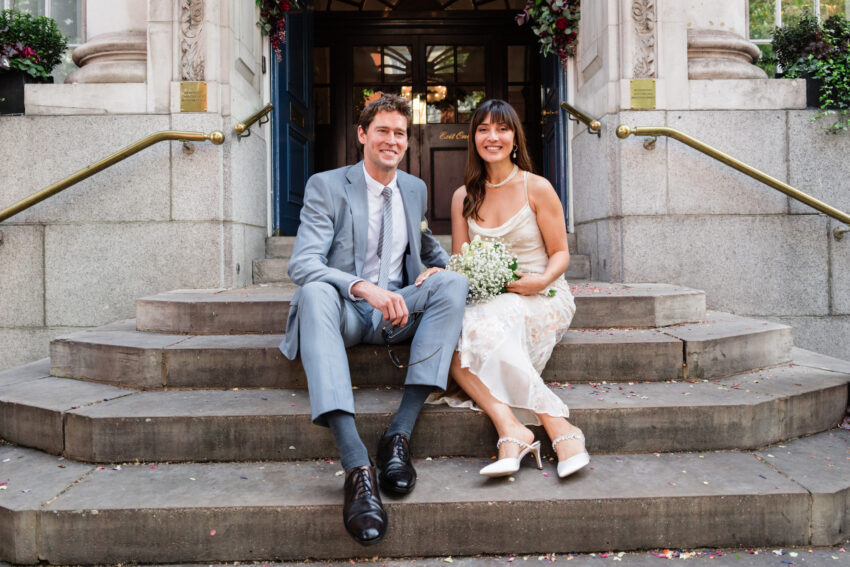 Bride and groom standing on the steps outside Chelsea Old Town Hall.