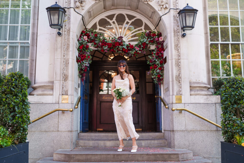 Bride portrait outside Chelsea Old Town Hall under the floral entrance.