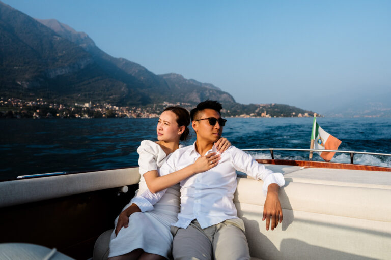 Couple sitting close together on a boat, leaning into each other during a Lake Como couples photoshoot.