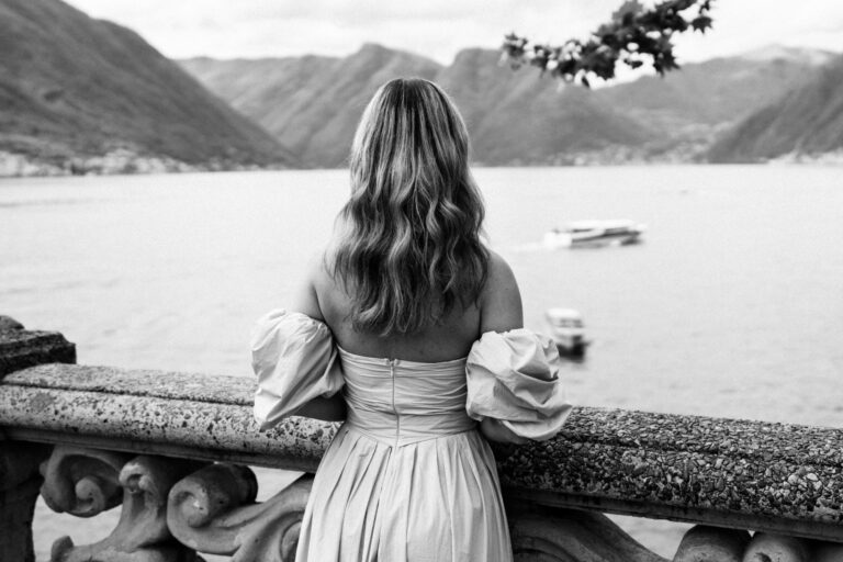 Woman standing at the balustrade, looking out over Lake Como at Villa del Balbianello.