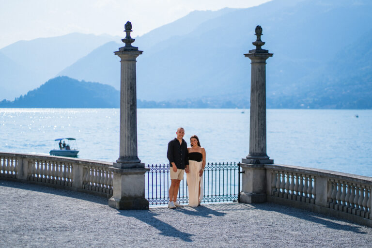 Couple standing together between stone columns at Villa Melzi, Lake Como.