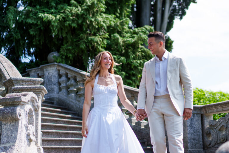 Couple holding hands while walking together through a park in Tremezzo during a Lake Como couples photoshoot.