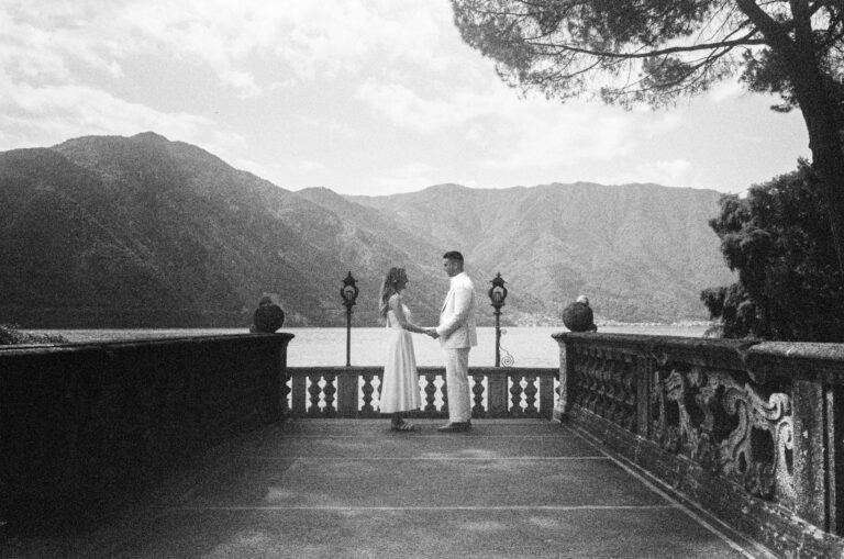 Couple standing together on a lakeside terrace during a Lake Como couples photoshoot.