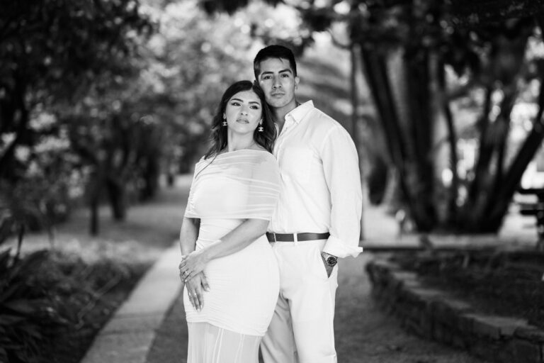 Black and white couple portrait standing close together along a tree-lined path in Lake Como.