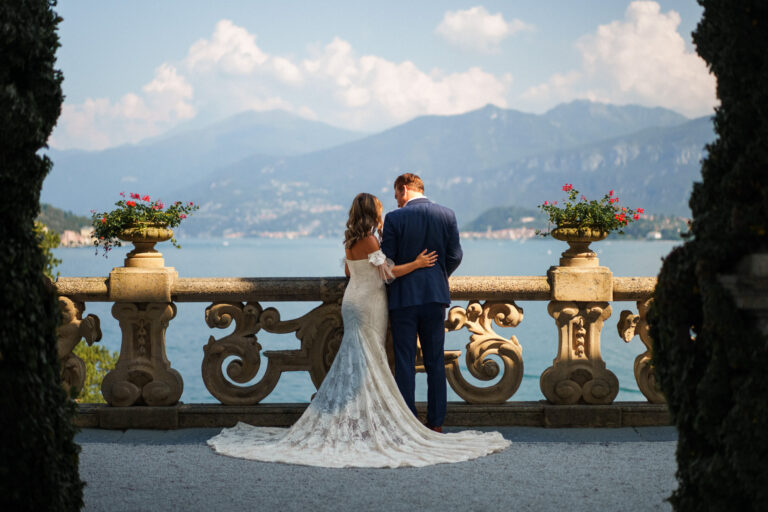 Couple standing together by the lake at Villa del Balbianello, Lake Como.