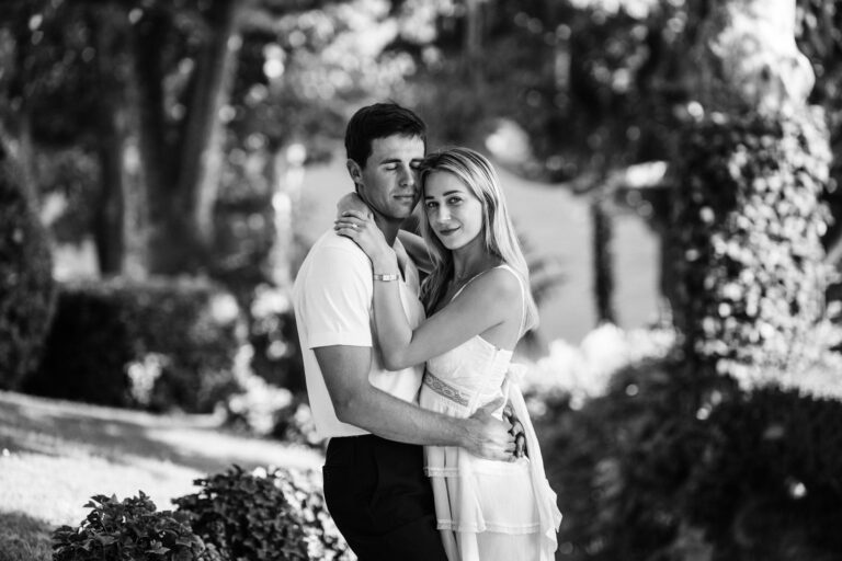 Couple holding each other in the gardens at Villa del Balbianello, Lake Como.