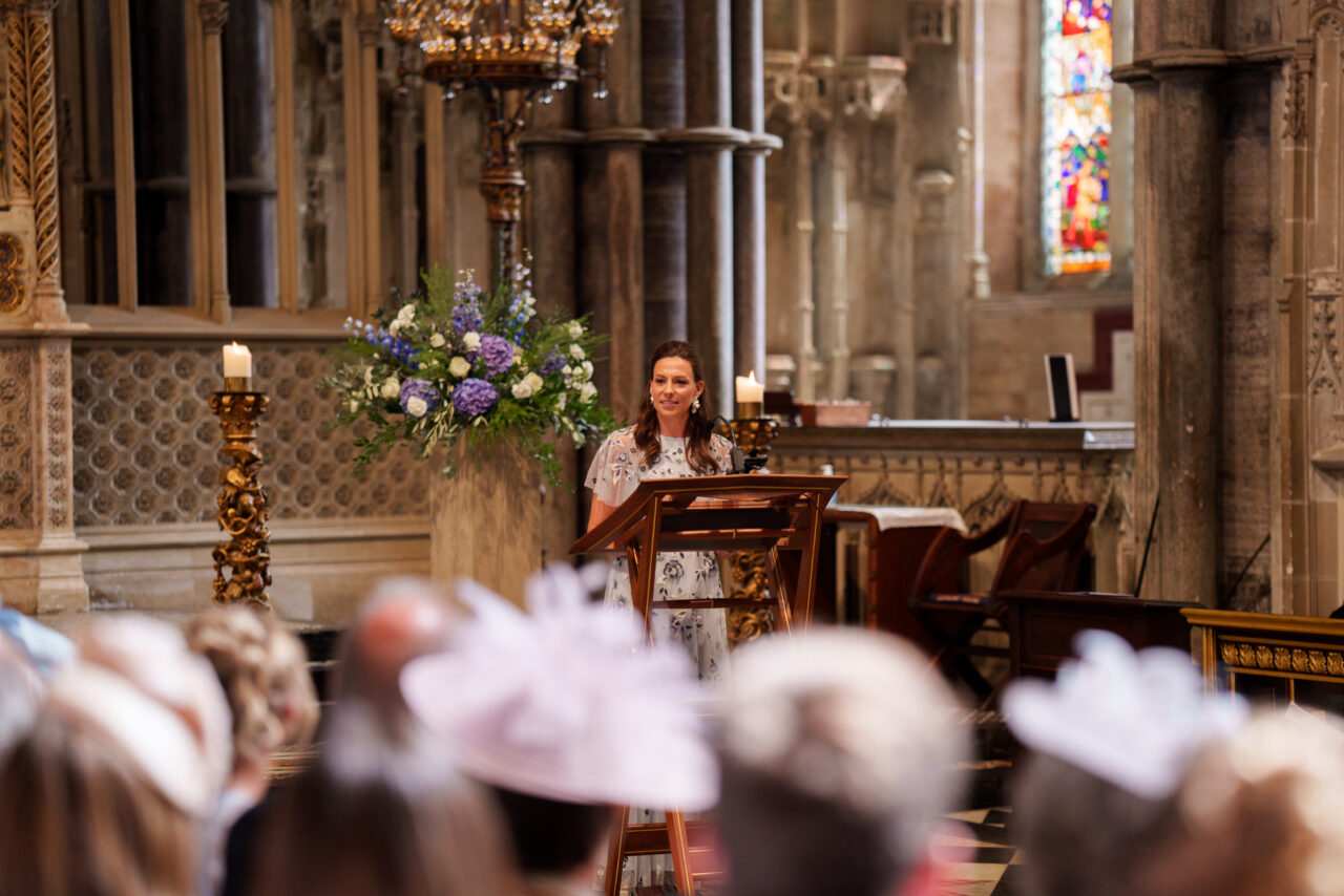 Reading delivered from the pulpit during the ceremony, floral arrangements and interior light providing balance and context.