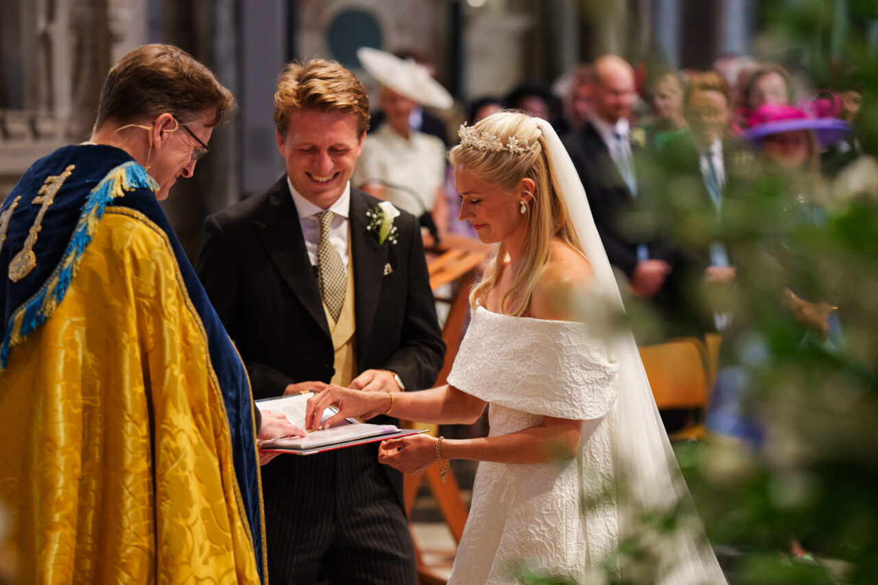 Bride and groom exchanging rings during a church ceremony, soft natural light falling across their hands, photographed by an Ely wedding photographer.