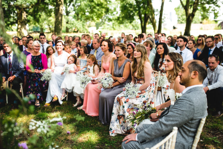 Guests seated outdoors during an Essex wedding ceremony, summery atmosphere.