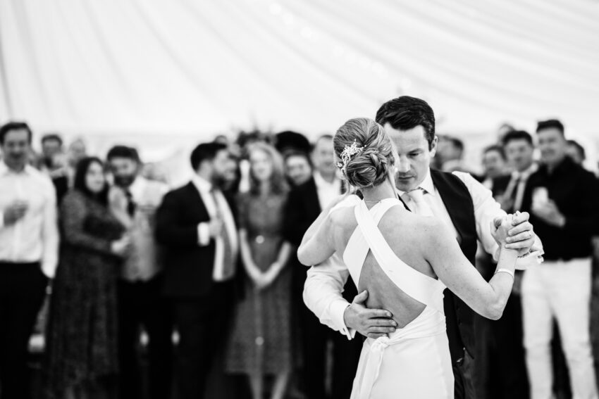 Bride and groom embracing on the dance floor, emotional and joyful.