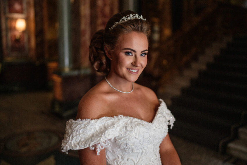 Bride in an off-the-shoulder dress, elegant portrait with soft background.