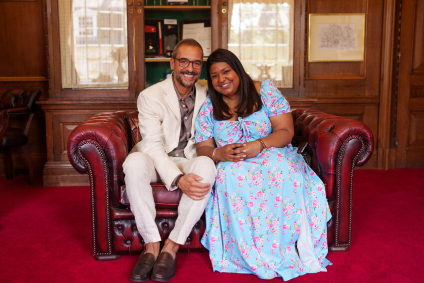 Guests seated together on a leather sofa inside Islington Town Hall during wedding celebrations.