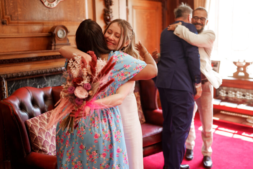 Bride hugging a guest inside Islington Town Hall after the ceremony.