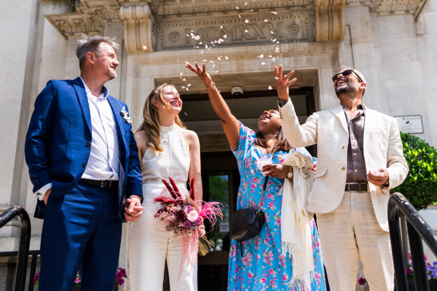 Confetti moment outside Islington Town Hall with friends celebrating around the couple.