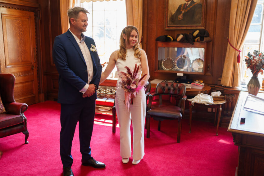 Bride and groom standing together during their wedding ceremony inside Islington Town Hall.