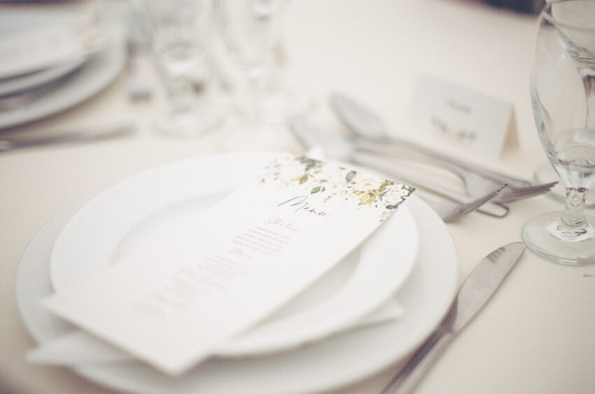 Wedding place setting with printed menu and glassware.