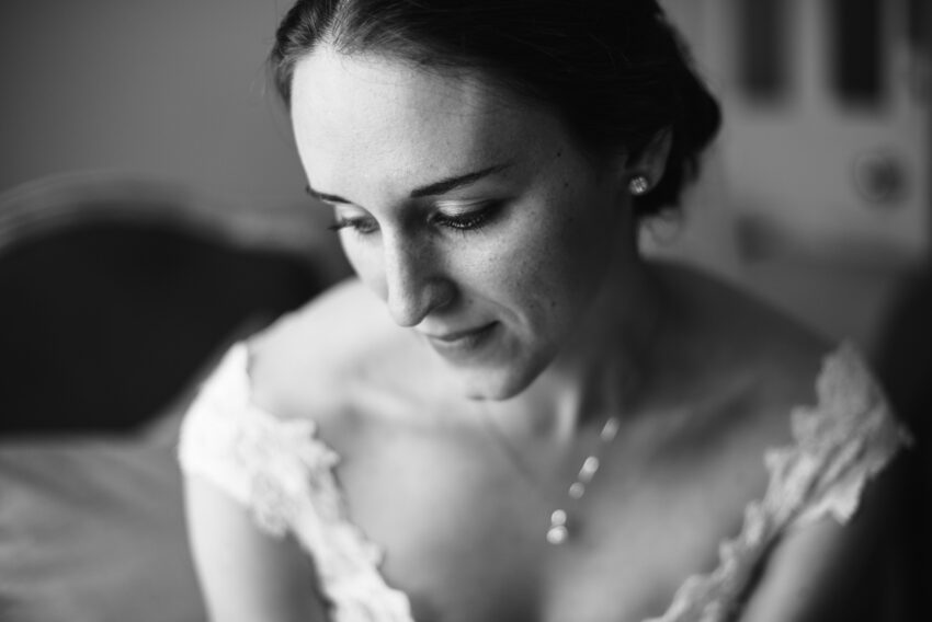 Bride getting ready in soft window light, photographed on film.