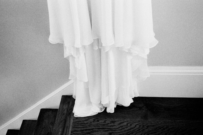 Wedding dress hanging above a staircase, photographed on film.