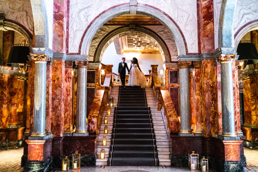 Bride and groom on teh grand staircase at Kimpton Fitzroy in London.