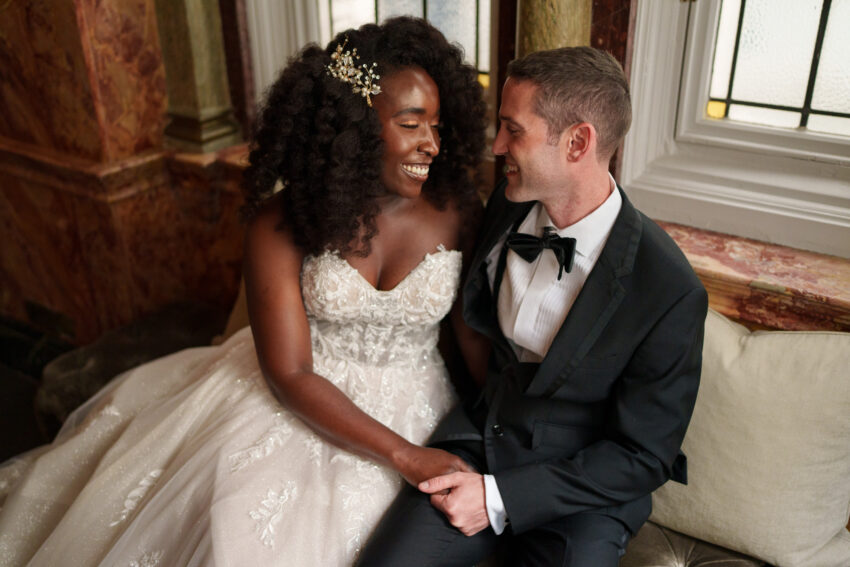 Bride and groom seated together during wedding portraits.
