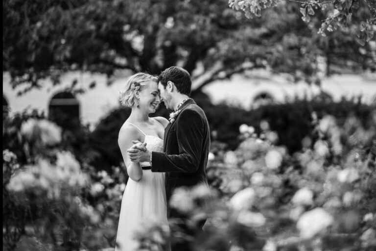 Black and white couple portrait in a garden with soft flowers in the foreground