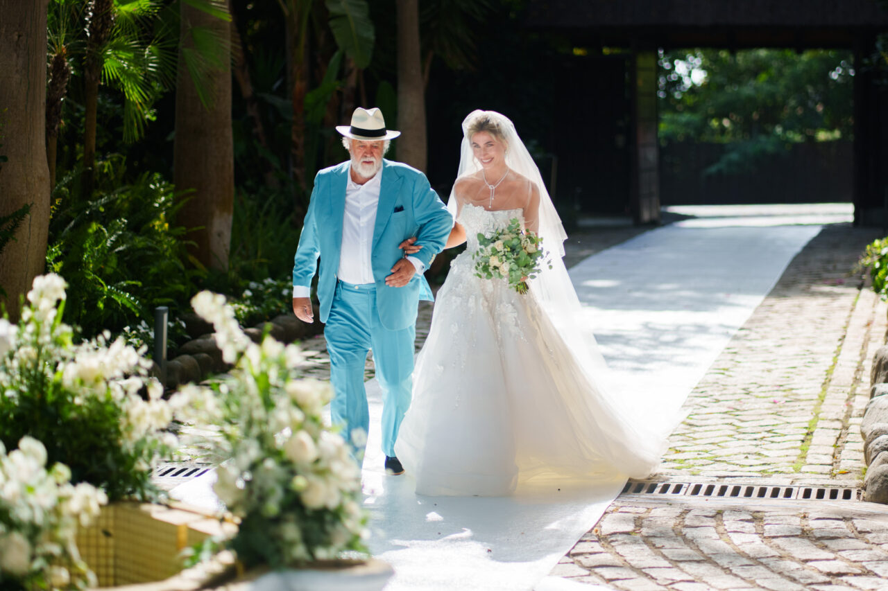 Bride walking with her father at a Malaga wedding venue with tropical garden setting (Marbella).