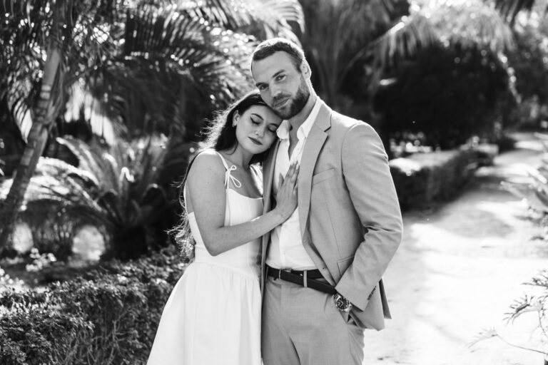 Couple embracing beneath palm trees during a romantic couples photoshoot in Málaga.