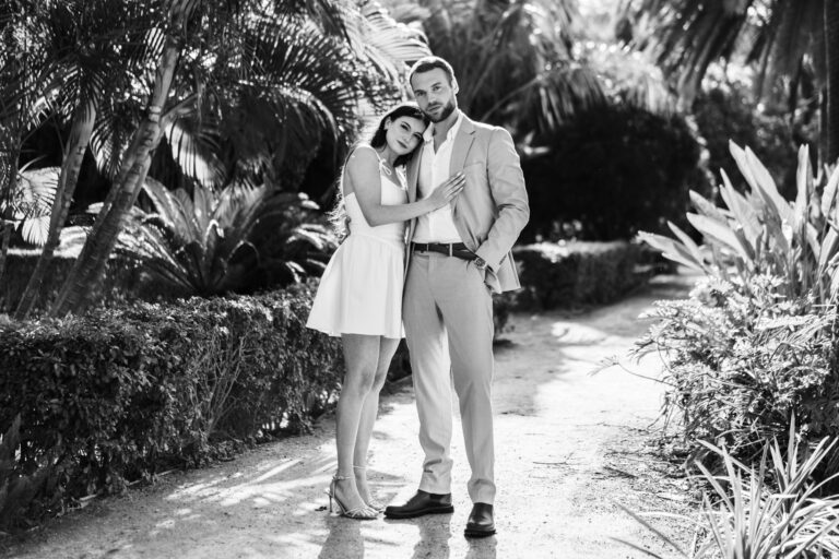 Couple walking together along a garden path during a black and white Málaga couples photoshoot.