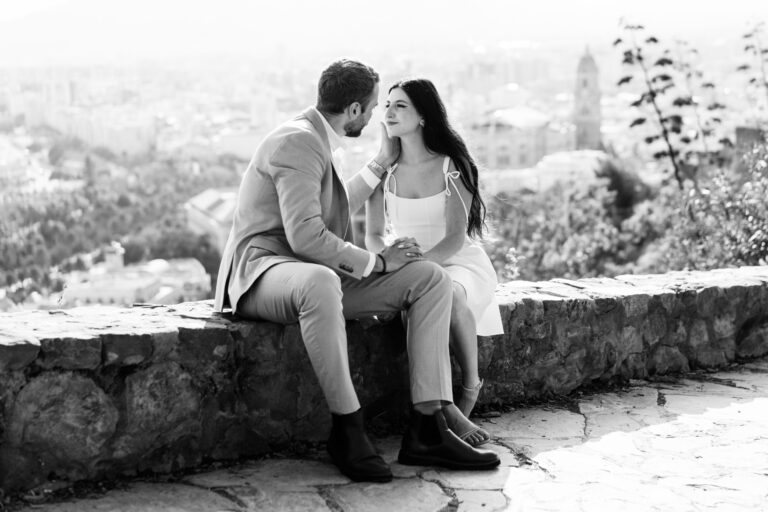 Couple sharing a quiet moment together on the Gibralfaro viewpoint overlooking the city of Málaga.