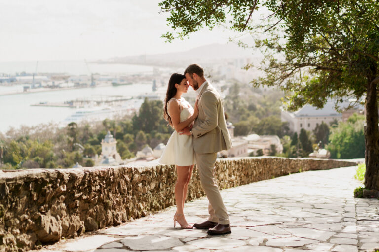 Couple embracing on the Gibralfaro viewpoint overlooking Málaga harbour.