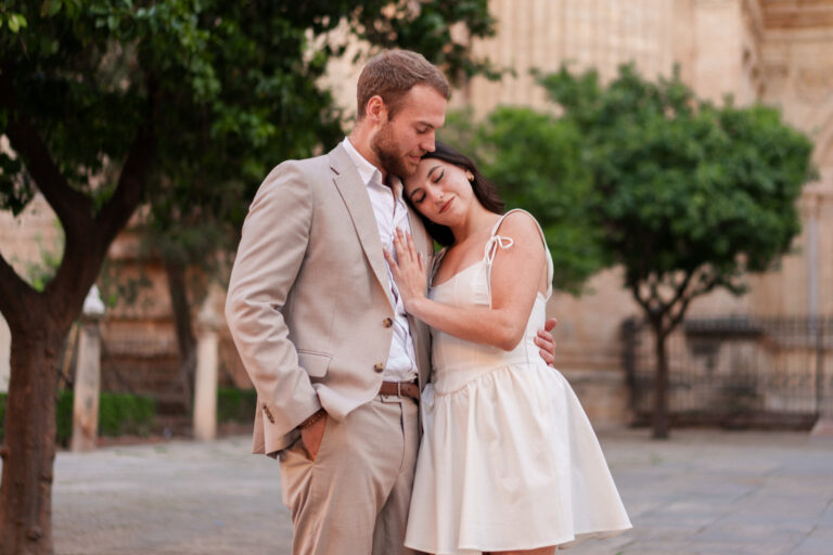 Couple holding each other in the square beside Málaga Cathedral.