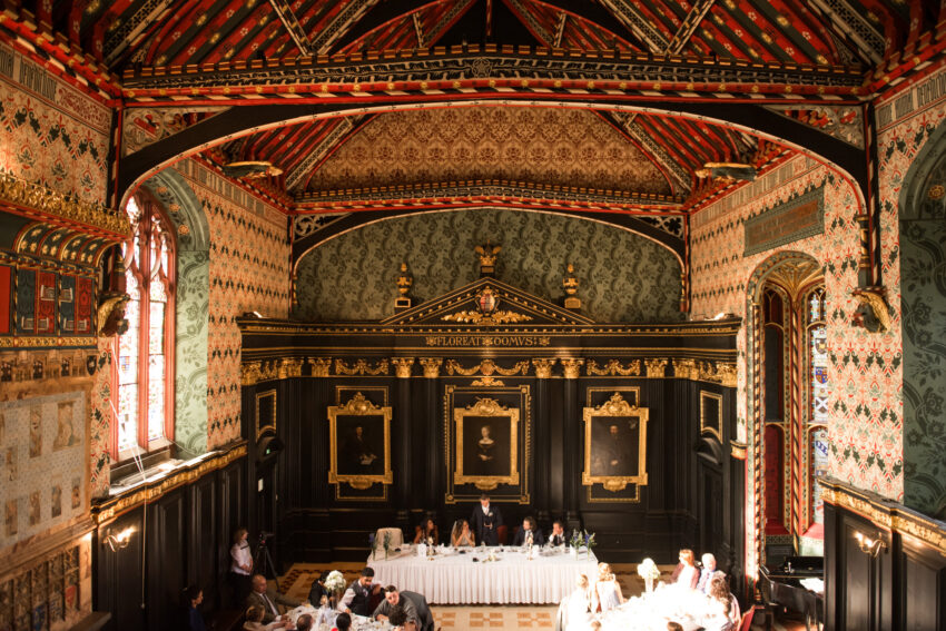 Grand wedding reception in the historic hall at Queens’ College Cambridge with ornate painted ceiling.