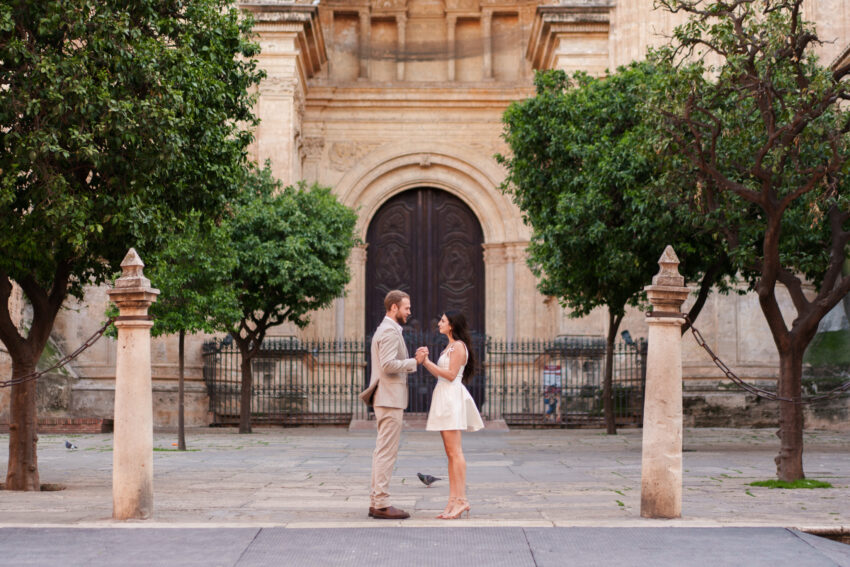 Couple standing together in front of the cathedral doors during a Málaga couples photoshoot in the historic centre.