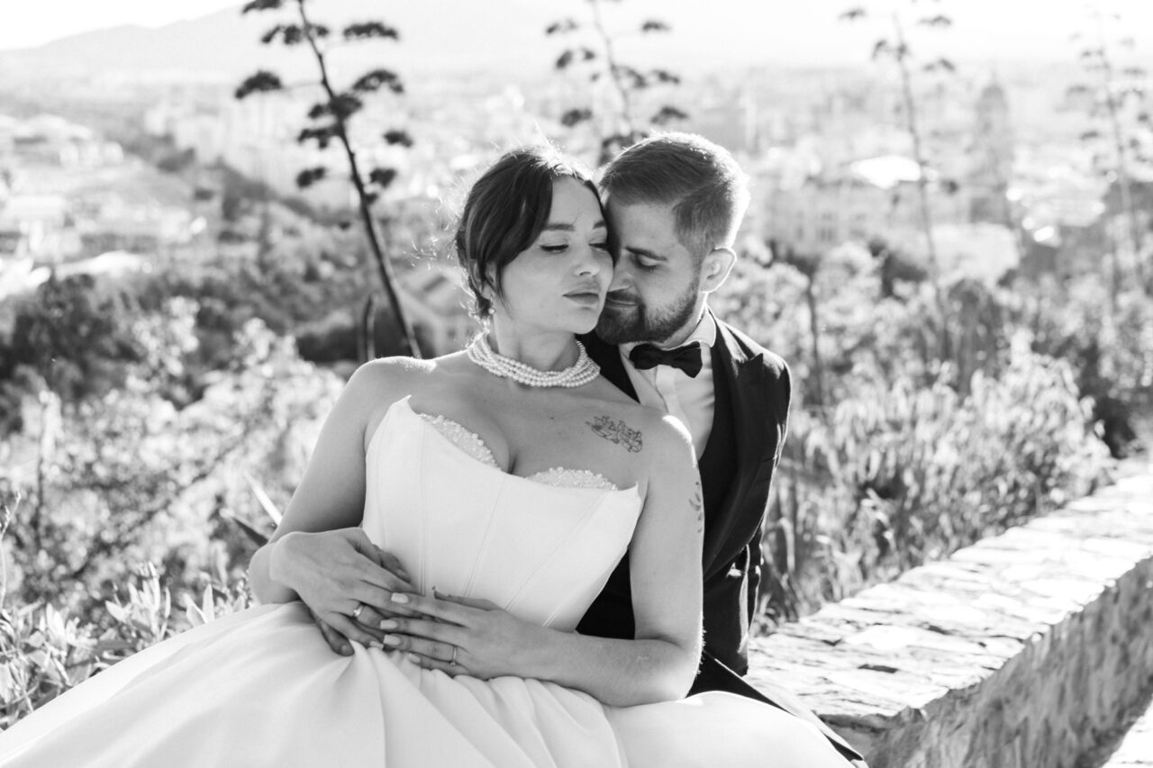 Bride and groom embracing at Gibralfaro hill, black and white wedding portrait in Malaga.