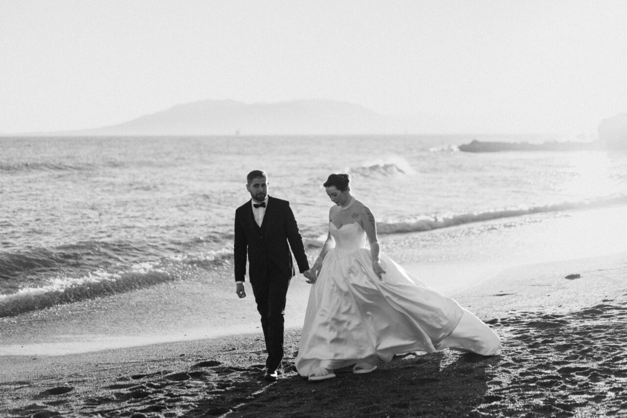 Bride and groom walking along the beach in Malaga, black and white wedding photograph.