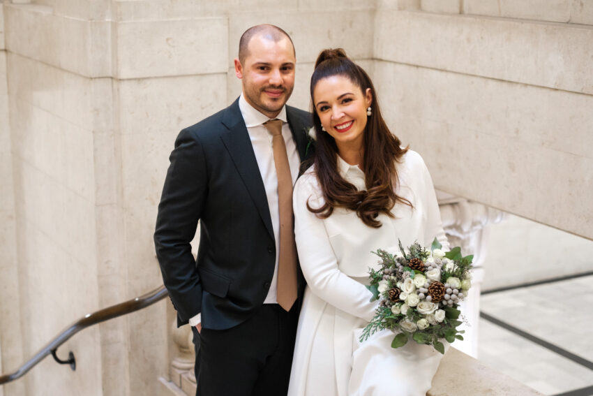 Bride and groom smiling together on the staircase inside Old Marylebone Town Hall.