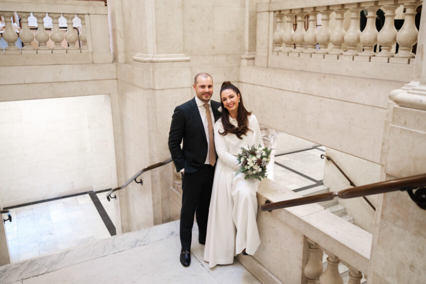 Bride and groom standing together on the steps outside Old Marylebone Town Hall.