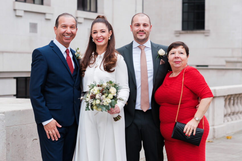 Bride and groom posing with family outside Old Marylebone Town Hall.